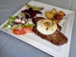 a plate of food with an egg and a salad at Hali Country Hotel in Gerdi