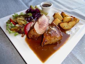a plate of food with meat and potatoes and a salad at Hali Country Hotel in Hali