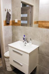 a bathroom with a white sink and a mirror at Modern Business Apartment close to City Center in Poznań