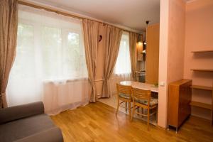ein Wohnzimmer mit einem Tisch und einem Fenster in der Unterkunft Apartments at Filevsky Park in Moskau