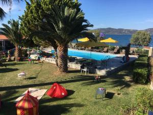 a resort with a palm tree and a swimming pool at Ariadnes Holiday Accommodation II in Apidias Lakos