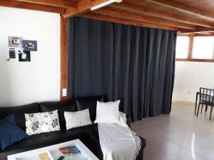 a living room with a black couch with pillows at Las Arecas Loft in Playa Blanca