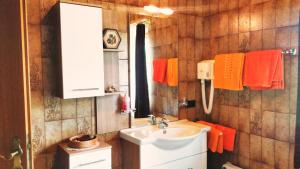 a bathroom with a sink and orange towels at Ferienwohnungen Wilhelmer in Liesing