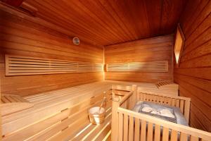 Una gran sauna de madera con un cubo. en Alpenhotel Rieger, en Mittenwald
