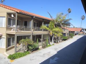 um edifício com palmeiras em frente a uma rua em Pacific Shores Inn em San Diego