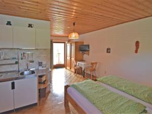 Sonnen的住宿－Small cosy apartment in the Bavarian Forest in a familiar atmosphere，一间卧室配有一张床,厨房配有桌子