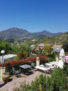 d'une terrasse avec des chaises et des tables et des montagnes en arrière-plan. dans l'établissement Costa Morroni, à Levanto