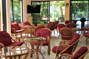 a room with tables and chairs and a tv at Brati - Arcoudi Hotel in Arkoudi