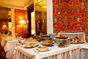 フィレンツェにあるホテル アルバーニ フィレンツェのケーキなどの食べ物を並べたビュッフェ式テーブル