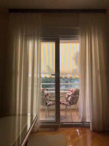 a room with a sliding glass door with a table and a chair at Apartment Sanja in Baška Voda