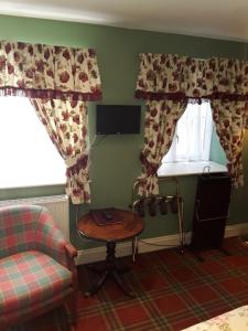 a living room with a table and two windows at Langport Arms Hotel in Langport