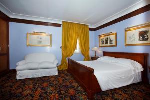 a hotel room with a bed and a chair at Hotel Albani Firenze in Florence