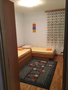 a small room with two beds and a rug at Apartment Sanja in Baška Voda