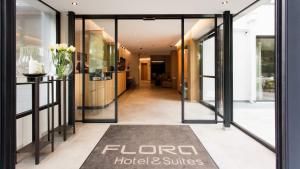 een lobby van een hotel met glazen deuren en een tapijt bij Flora Hotel & Suites in Merano