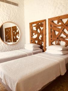 two beds in a room with a mirror on the wall at Alaçatı Ala Hotel - Special Category in Alacati