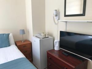 a hotel room with a bed and a television at The Manchester Hotel in Bournemouth