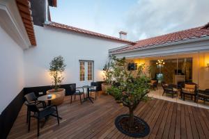 a patio with tables and chairs on a wooden deck at Pousada Vila Óbidos in Óbidos