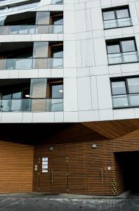 a large building with a wooden garage in front of it at Modern Business Apartment close to City Center in Poznań