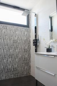 セットにあるVilla La Perle de Thauのバスルーム(シャワー、洗面台、鏡付)