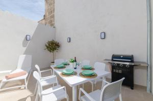 un comedor blanco con una mesa y sillas blancas en Na Valenta, en Artà