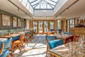 a restaurant with wooden tables and blue chairs at The Dolphin in Newbury