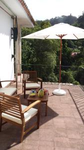 a patio with two benches and an umbrella at Casa do Lado - Tourism with Character in Sintra