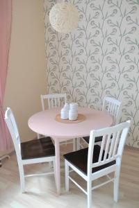 una mesa rosa y sillas en una habitación con pared en Vee 4 City Center Apartment en Pärnu