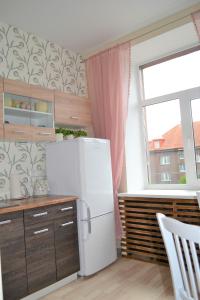 cocina con nevera blanca y ventana en Vee 4 City Center Apartment en Pärnu