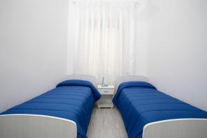 マルサラにあるAria Di Mare B&bのベッド2台が隣同士に設置された部屋です。