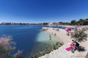 a group of people on a beach in the water at Breki Apartman in Podstrana