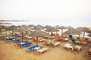 une vue aérienne d'une plage avec des chaises et des parasols dans l'établissement Athena Apartment, à Artemi