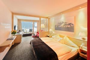 ein Hotelzimmer mit einem Bett und einem großen Fenster in der Unterkunft Eiger Mountain & Soul Resort in Grindelwald