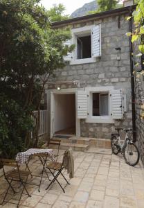 una casa con patio y una bicicleta estacionada frente a ella en Seven Hills Duplex Eco-Cottage en Kotor