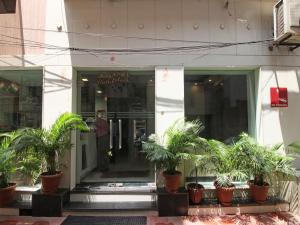 a building with potted plants in front of it at Hotel Baba Inn-By RCG Hotels in New Delhi