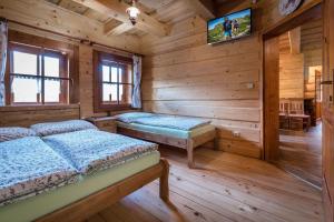 a bedroom with two beds in a log cabin at Chata u strýka Joža in Terchová