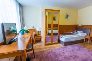 a living room with a desk and a bedroom at Pannonia Hotel in Sopron +30 photos