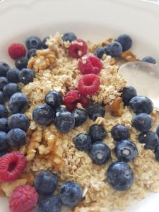 a bowl of granola with blueberries and raspberries at Paradise Island Estate in Choeng Mon Beach