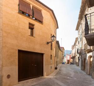 an alley with a building with a garage at La Caseta de Porrera in Porrera