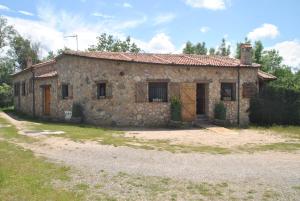 an old stone house sitting on a dirt road at Casa Rural Los Regajales in Tenzuela