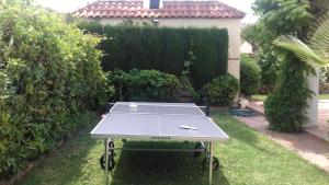a ping pong table in a yard with a hedge at Los Arcos in Marbella