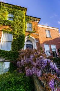 un edificio con flores púrpuras delante de él en Butlers Townhouse en Dublín