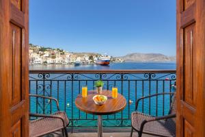 - une table sur un balcon avec vue sur l'eau dans l'établissement Marias Sea House, à Symi