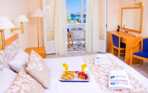 Syros Atlantis في Vári: غرفة بها سرير مع صينية من الفواكه عليها