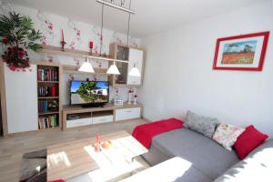 Una sala de estar con un sofá y un televisor. en Bungalow am Schmachter See by Rujana, en Binz