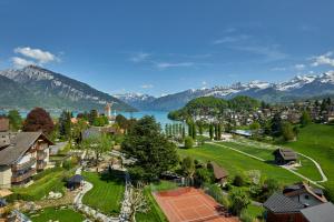 an aerial view of a town with a lake and mountains at Hotel Eden Spiez in Spiez