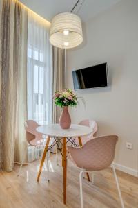 een kamer met een tafel en stoelen en een vaas met bloemen bij Royal Theatre Studio and Room in Split
