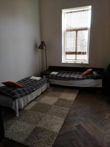 two beds sitting in a room with a window at Bartas apartment in Liepāja