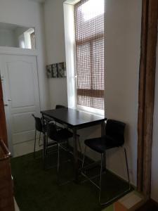 a table and chairs in a room with a window at Bartas apartment in Liepāja