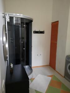 a bathroom with a shower and a black bench in it at Bartas apartment in Liepāja