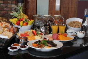 a table topped with plates of food and bowls of fruit at Absolute Hotel Limerick in Limerick